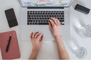 Homem criando produto digital em seu notebook com elementos gráficos de crescimento e sucesso