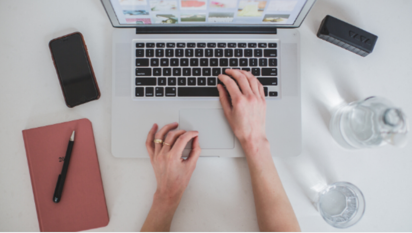 Homem criando produto digital em seu notebook com elementos gráficos de crescimento e sucesso