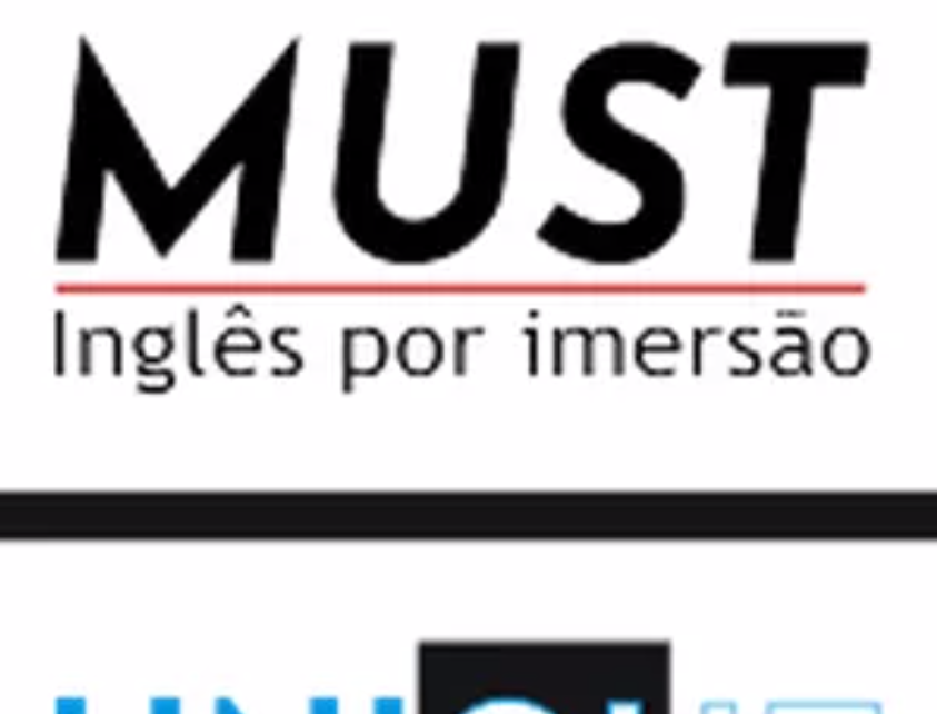 Estudante sorrindo enquanto estuda inglês online em um laptop com materiais de curso.